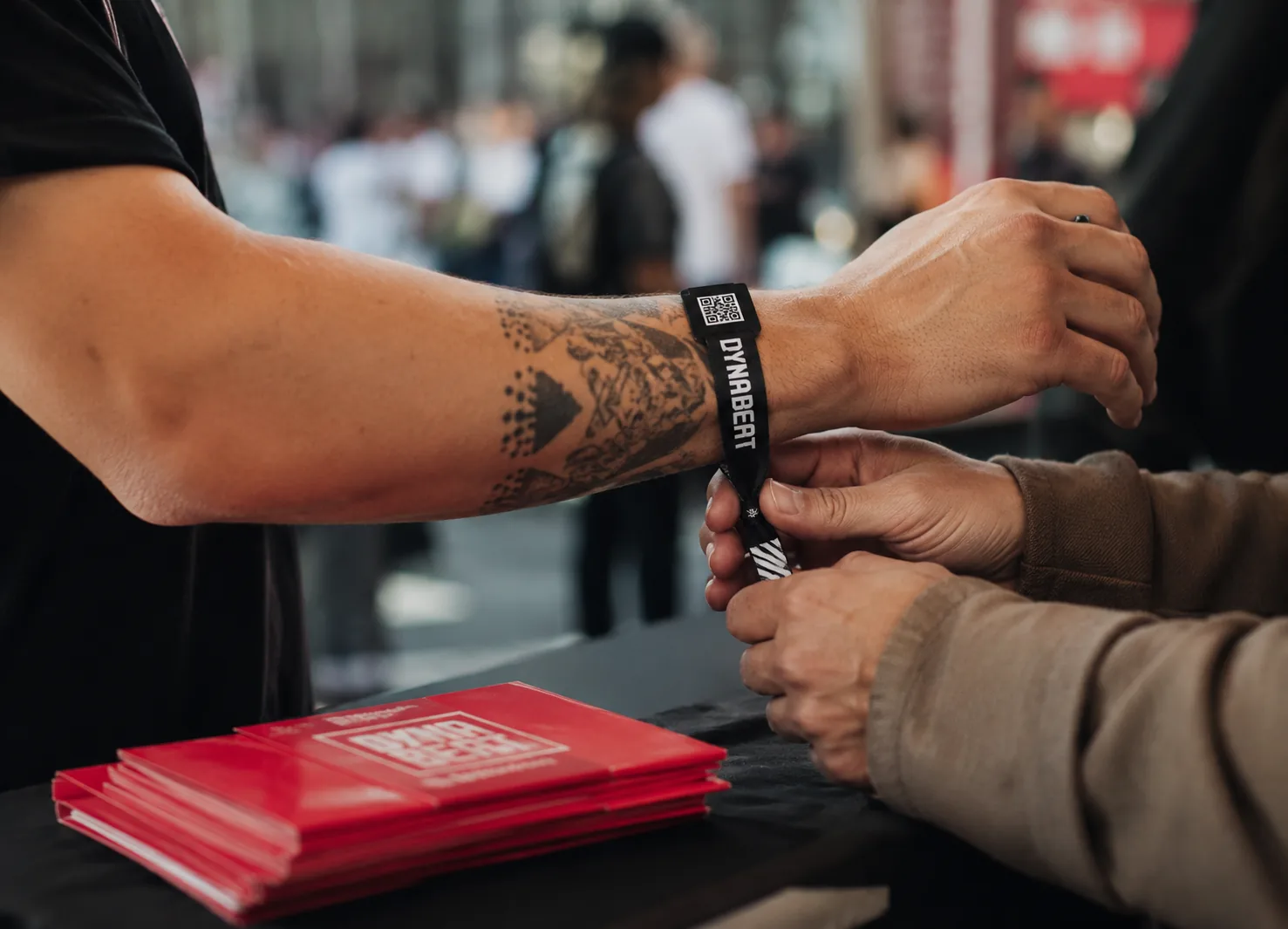 DYNABEAT Festivalarmband mit einem Code zum Scannen wird einem Gast am Eingang angelegt